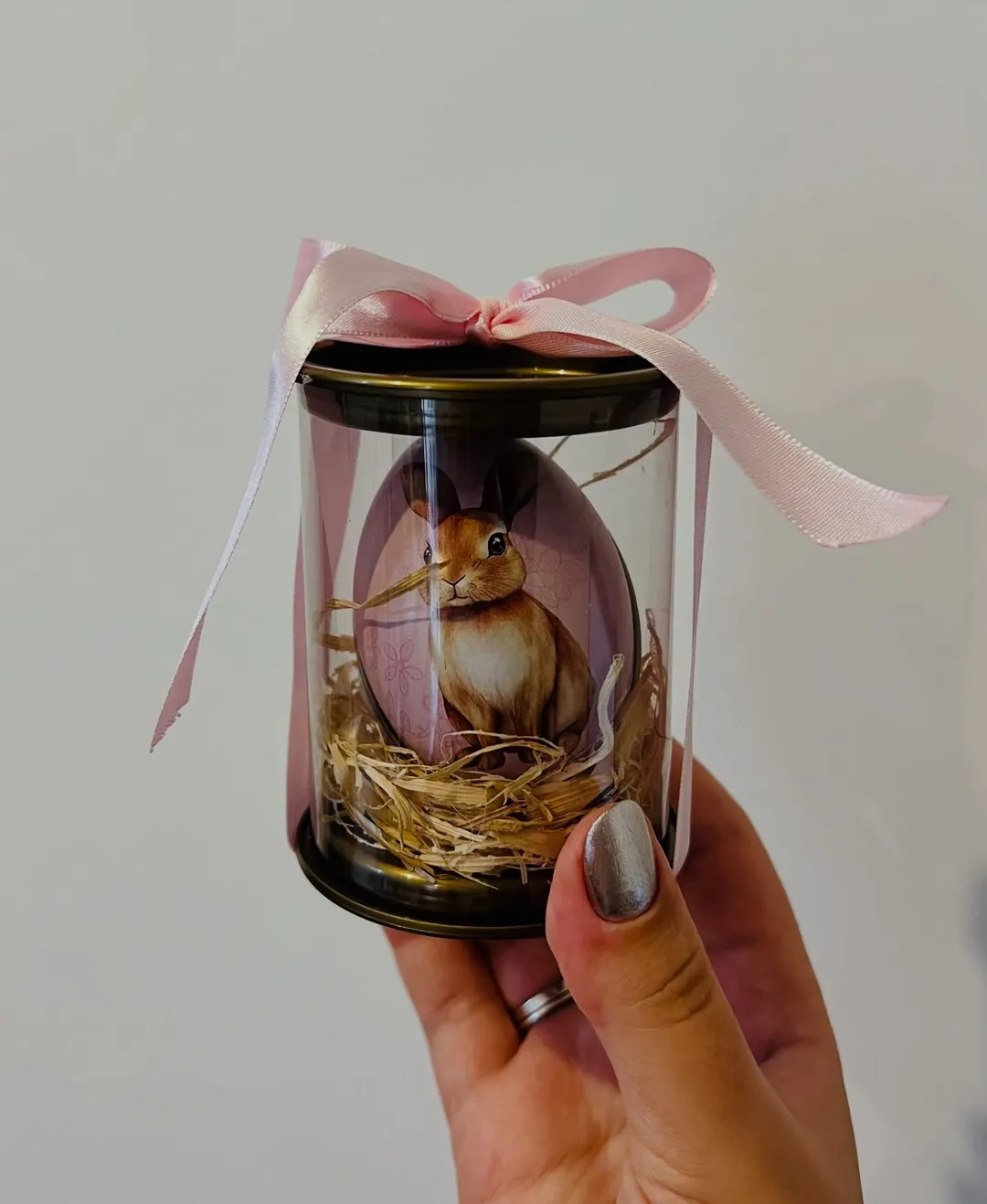 Lembrancinha de Páscoa: vela de 30g em pote com ilustração de coelho, ninho de palha e laço rosa